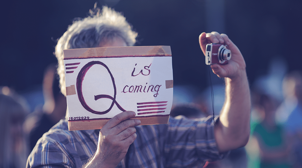 Man holding a paper Q is coming