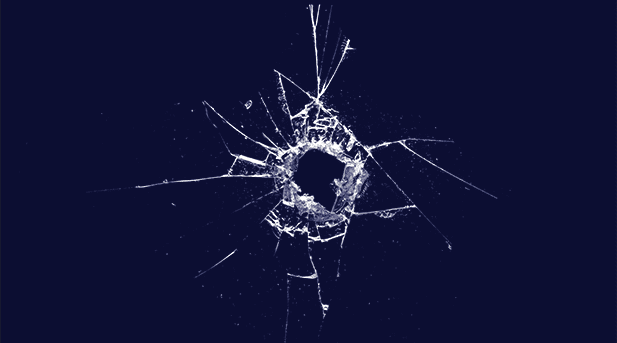 Bullet hole in shattered glass on a dark background.