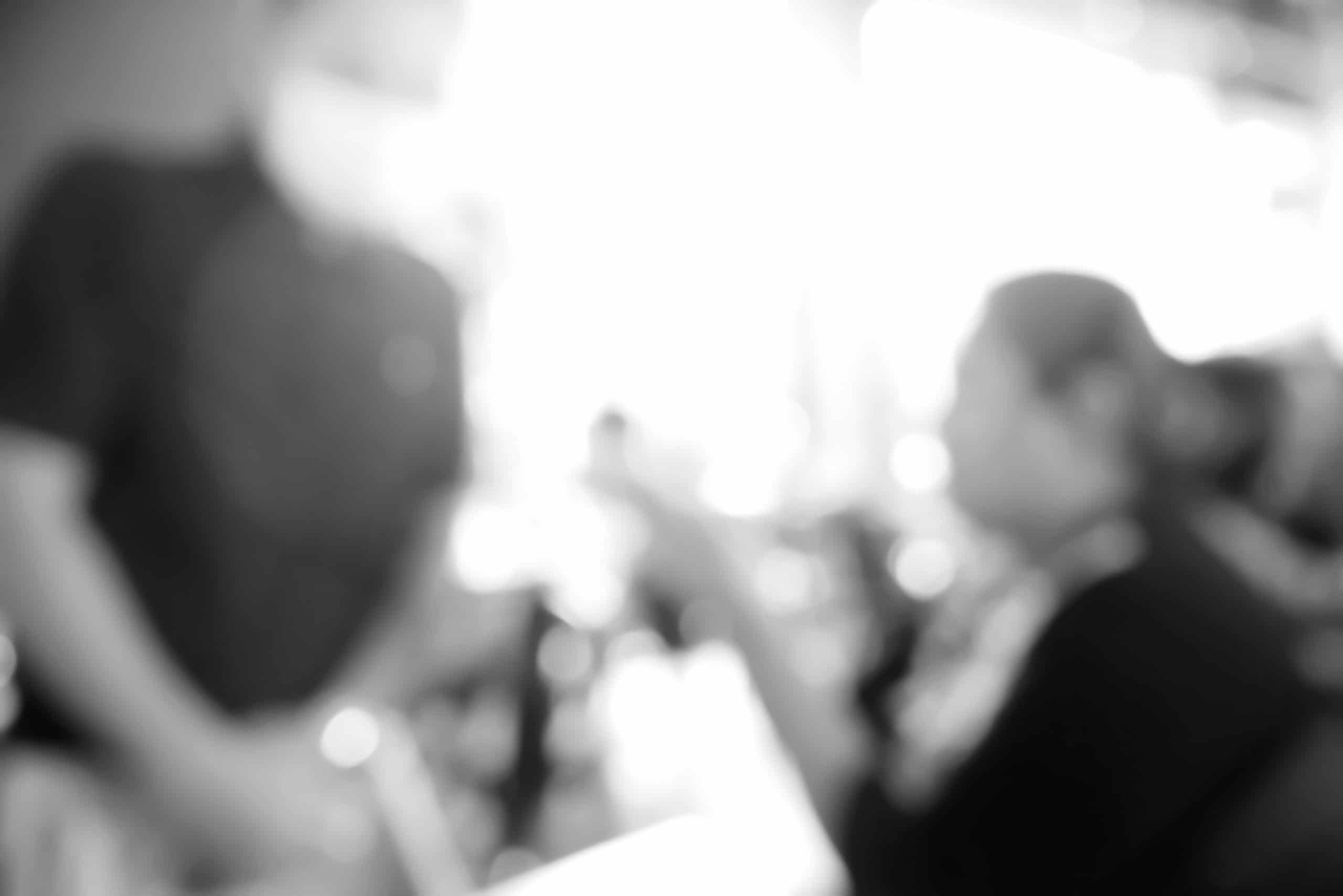 Blurred image of a person speaking to a healthcare worker wearing a mask.