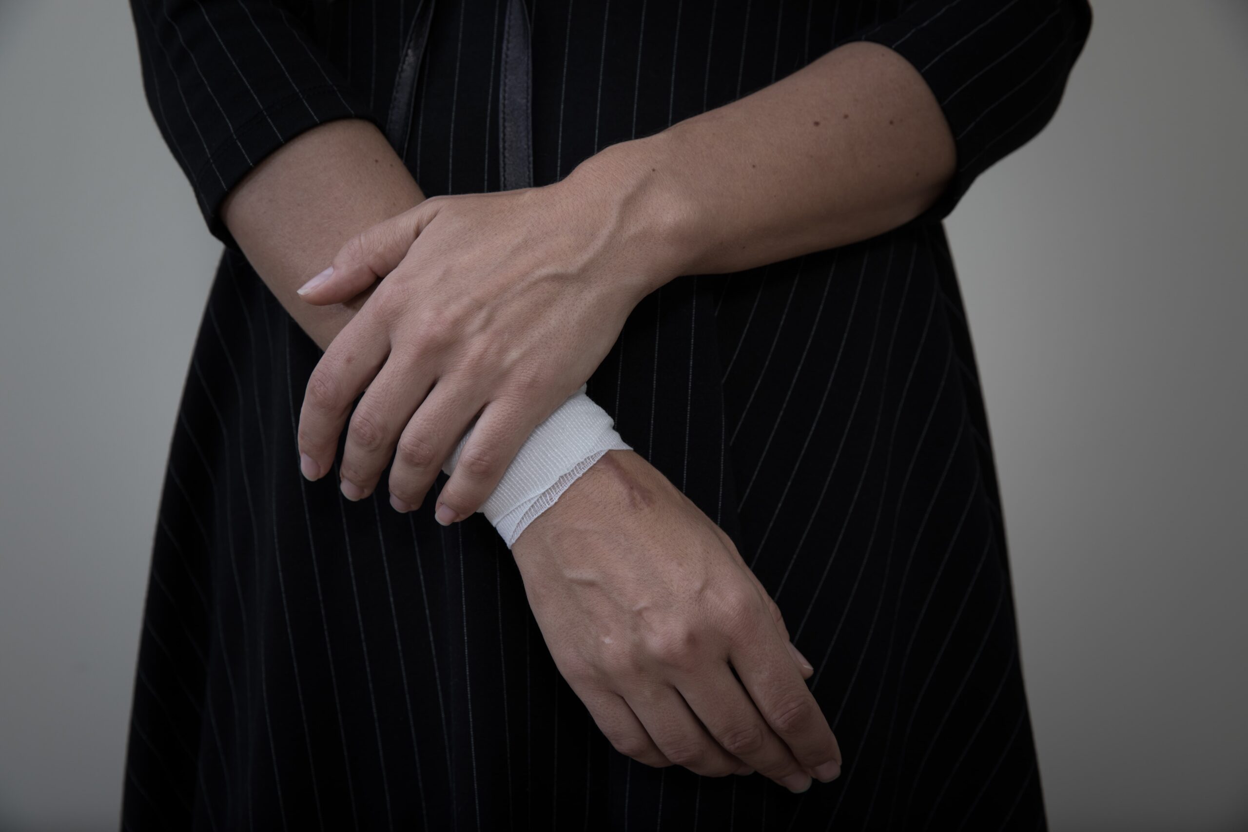 Person with a bandaged wrist symbolizing self-harm trends and support