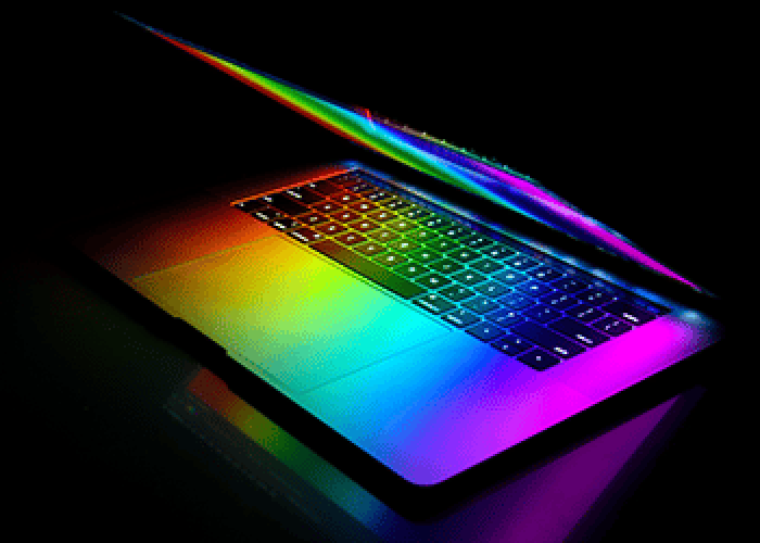A partially open laptop with rainbow-colored lighting illuminating the keyboard and screen