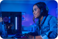 oung woman wearing headphones, playing a video game on a computer in a blue-lit room.